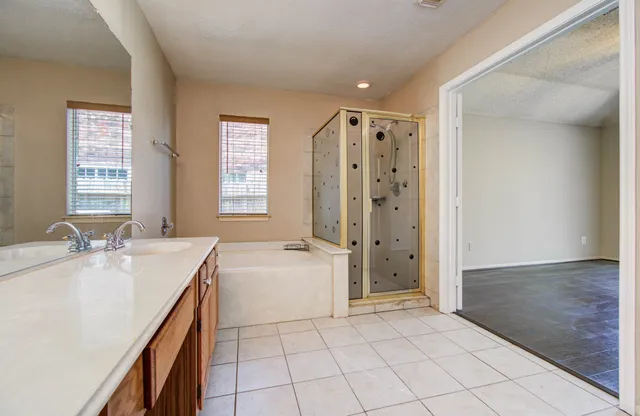 a spacious bathroom with a double vanity sink mirror and a bath tub
