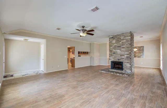 an empty room with fireplace and windows