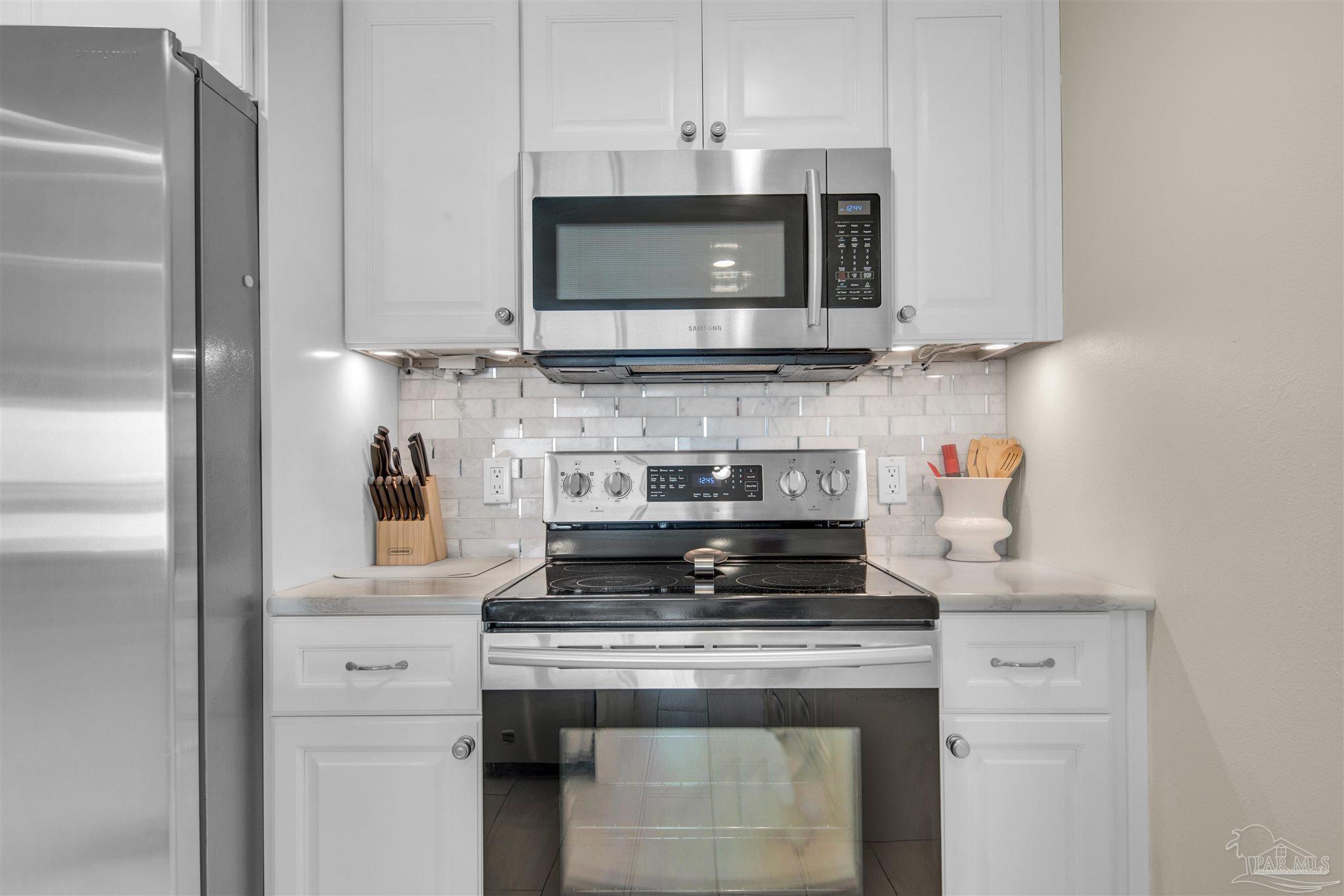 900 Fort Pickens Road, Unit 425 Pensacola Beach, FL 32561 - Photo 15 of 47 a kitchen with stainless steel appliances granite countertop a stove and a microwave