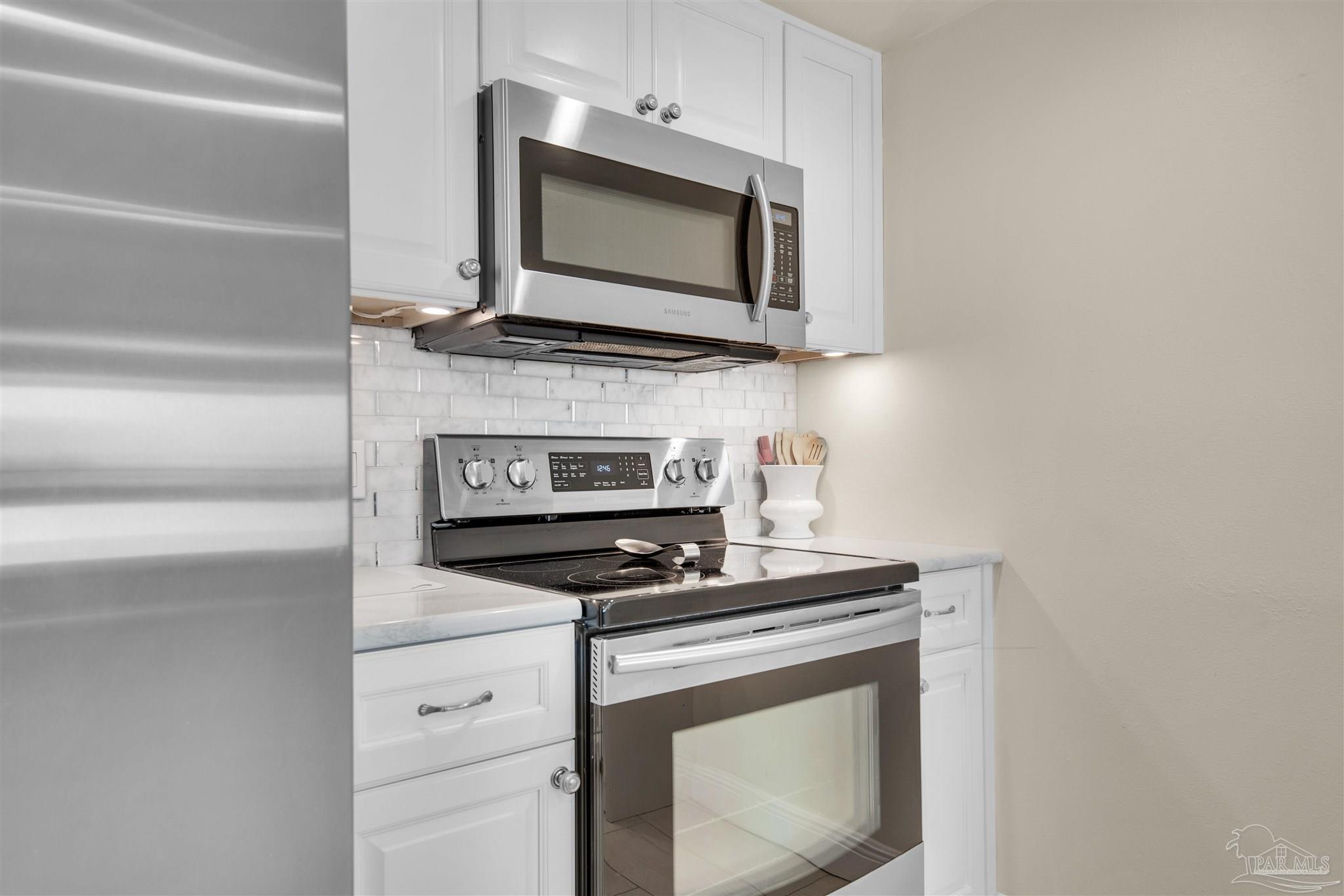 900 Fort Pickens Road, Unit 425 Pensacola Beach, FL 32561 - Photo 16 of 47 a kitchen with microwave cabinets and stove top oven