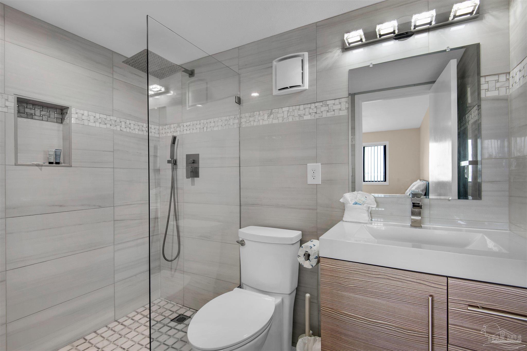 900 Fort Pickens Road, Unit 425 Pensacola Beach, FL 32561 - Photo 24 of 47 a bathroom with a toilet a sink a shower and mirror