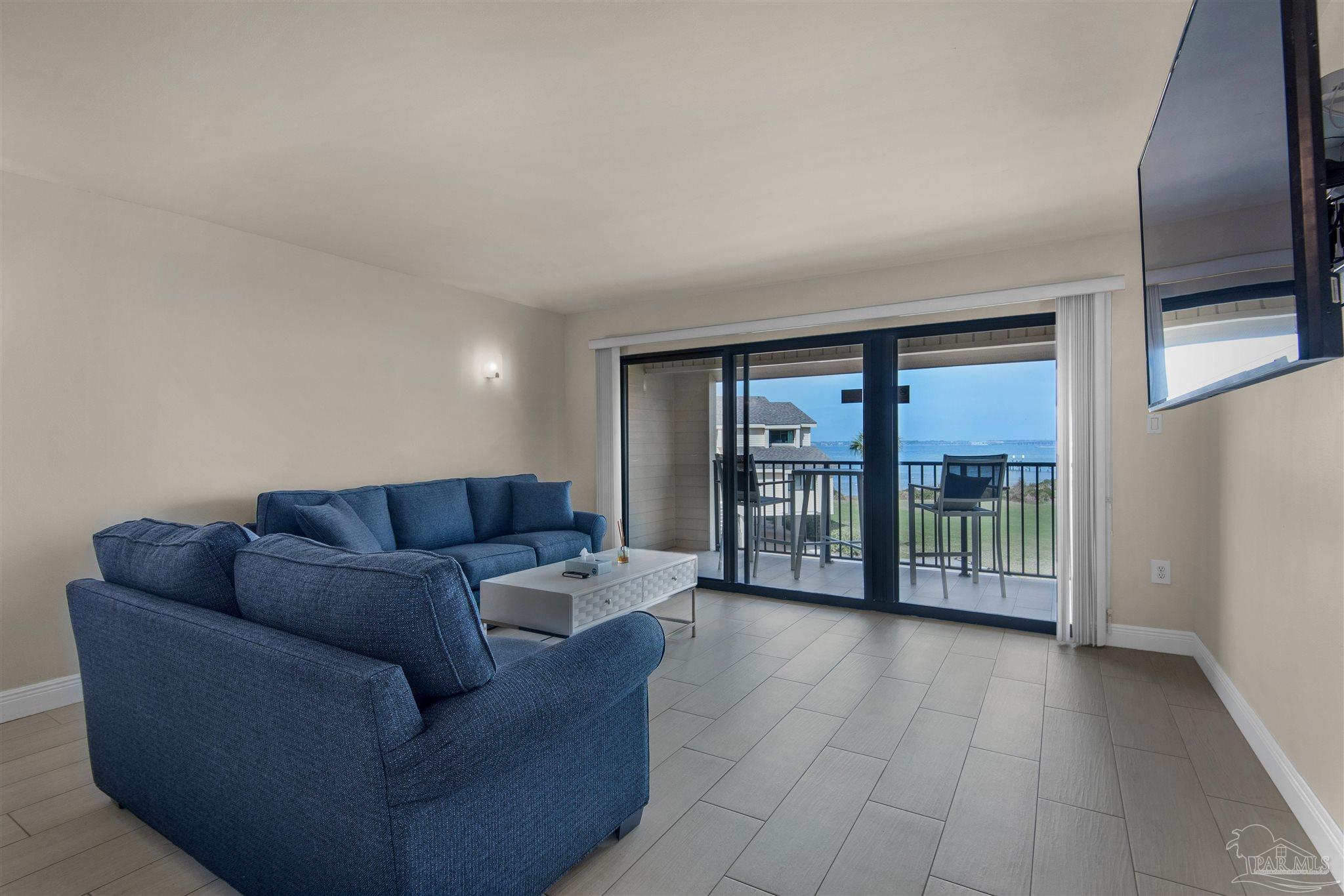 900 Fort Pickens Road, Unit 425 Pensacola Beach, FL 32561 - Photo 8 of 47 a living room with furniture and a flat screen tv