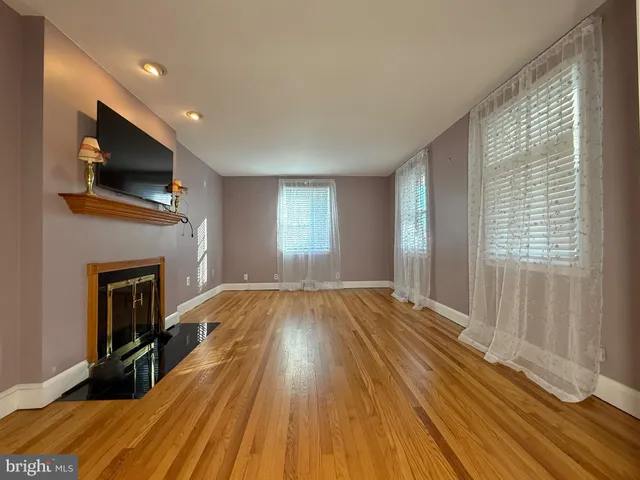 a view of empty room with wooden floor and fireplace