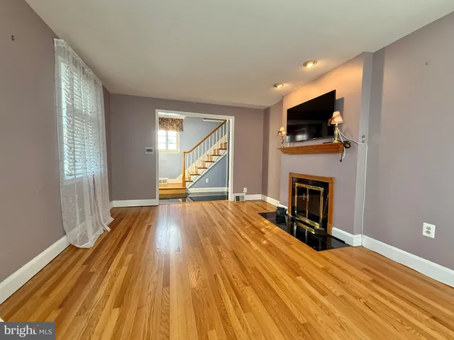 a view of a livingroom with wooden floor and a flat screen tv