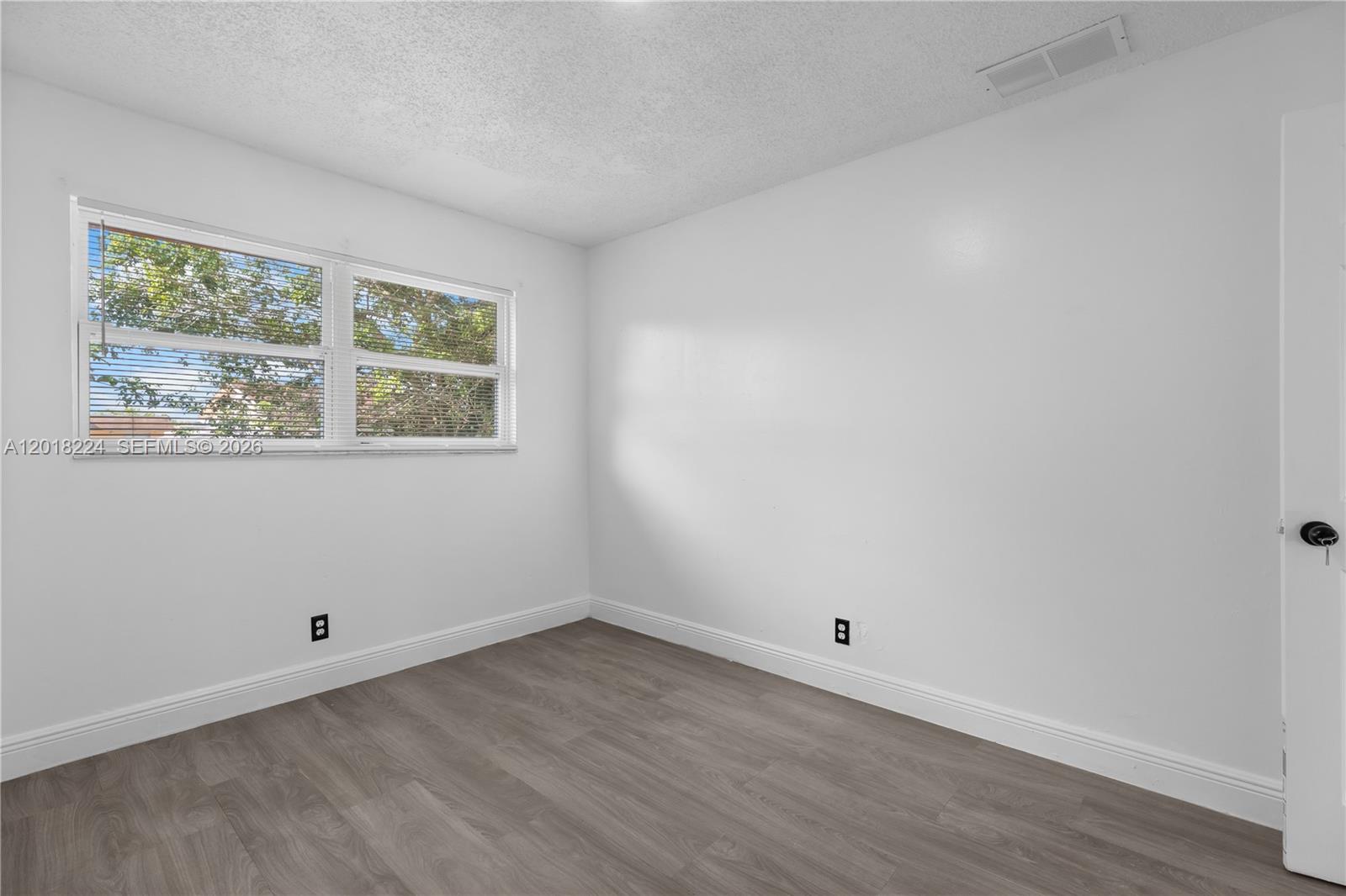 7958 Southwest 6th Street Pompano Beach, FL 33068 - Photo 31 of 57 a view of an empty room with wooden floor and a window
