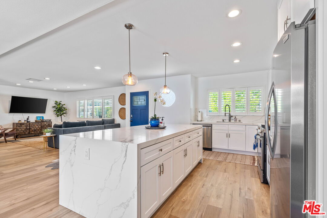 1399 Tamarisk Road Palm Springs, CA 92262 - Photo 11 of 28 a large kitchen with kitchen island white cabinets and stainless steel appliances