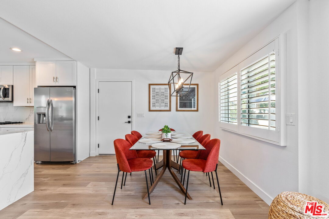 1399 Tamarisk Road Palm Springs, CA 92262 - Photo 13 of 28 a view of a dining room with furniture window and wooden floor