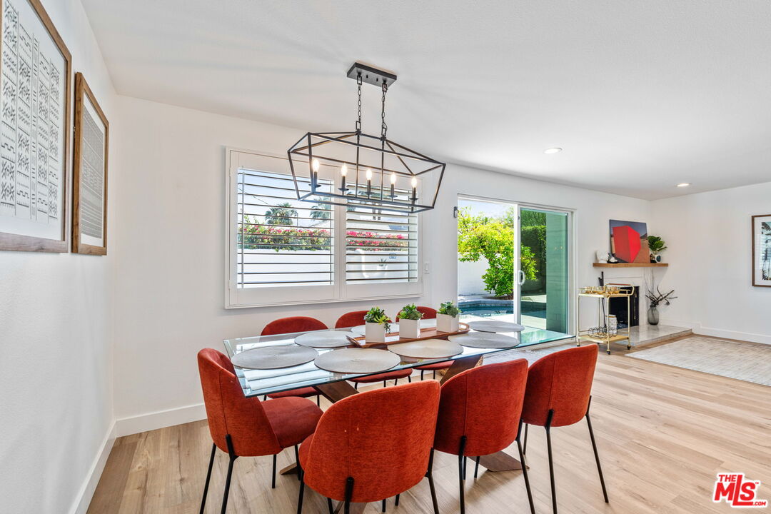 1399 Tamarisk Road Palm Springs, CA 92262 - Photo 7 of 28 a dining room with furniture a chandelier and wooden floor