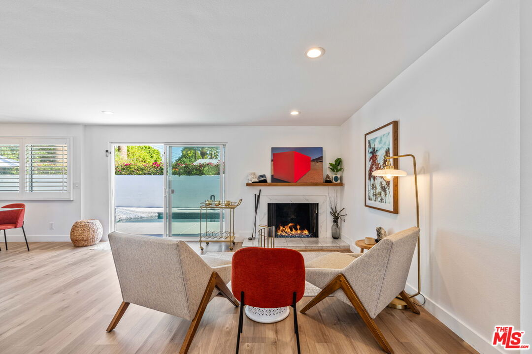 1399 Tamarisk Road Palm Springs, CA 92262 - Photo 10 of 28 a living room with furniture and a wooden floor