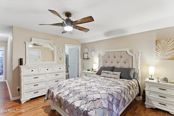 a bedroom with a bed and a mirror on the dresser