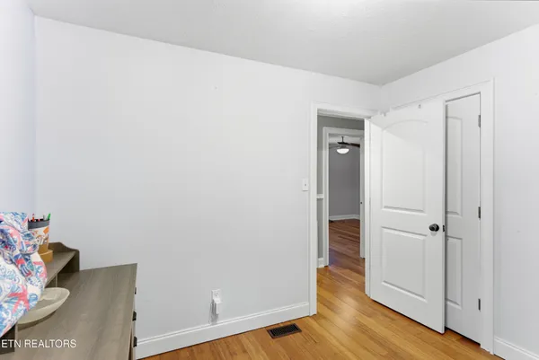 a view of a hallway with wooden floor and closet