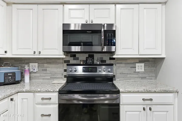 a kitchen with stainless steel appliances granite countertop a stove and a microwave