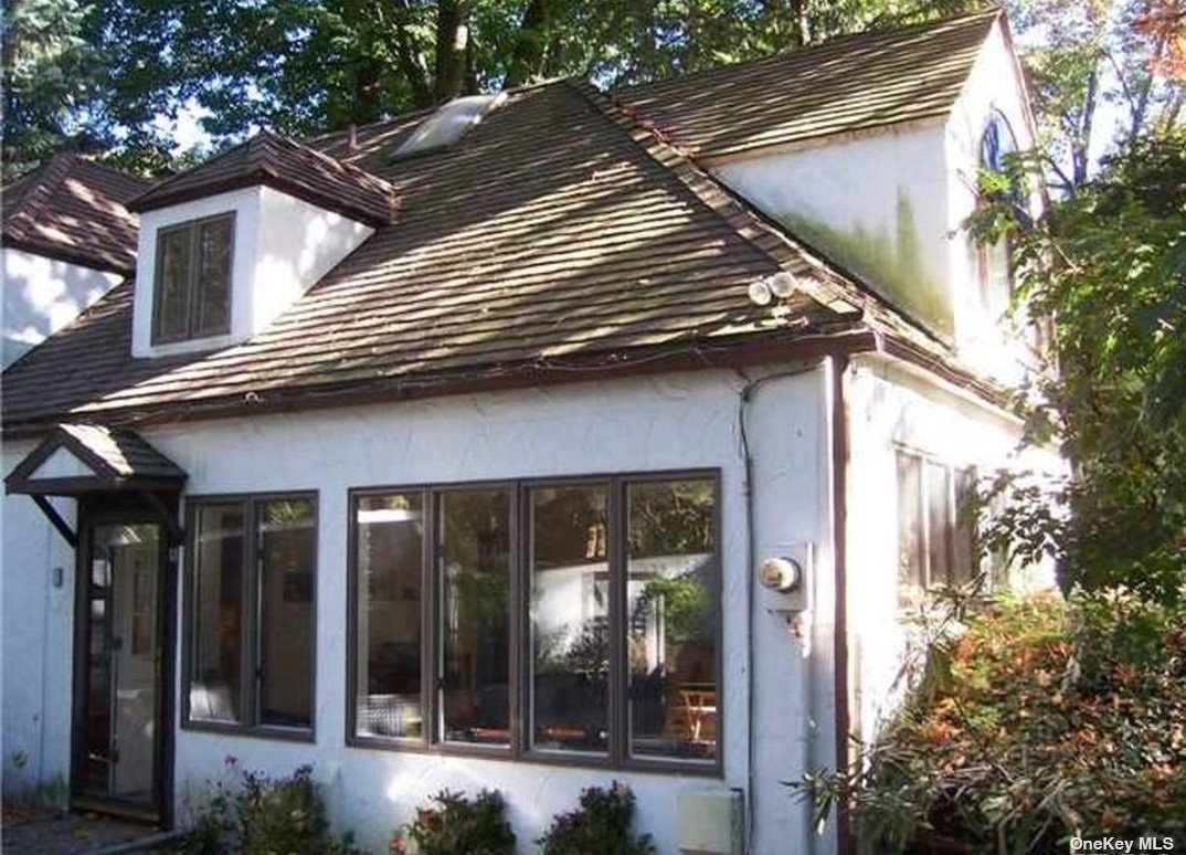 a view of a house with a large window and a tree