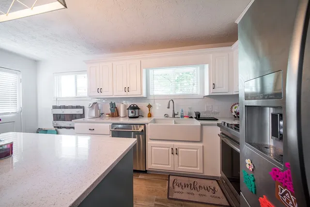 a kitchen with a sink stove top oven and refrigerator