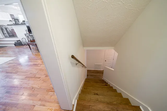 a view of a hallway with wooden floor and staircase