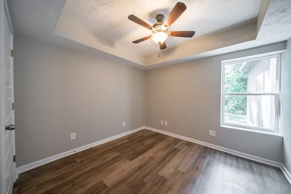 an empty room with a window and a fan