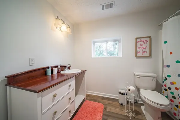 a bathroom with a granite countertop toilet sink and mirror