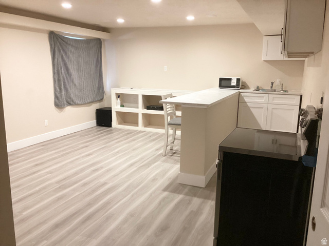 3071 Slate Rock Road Magna, UT 84044 - Photo 20 of 24 Recessed lighting, wood-finish flooring, built-in shelving, white cabinetry, and a kitchen counter