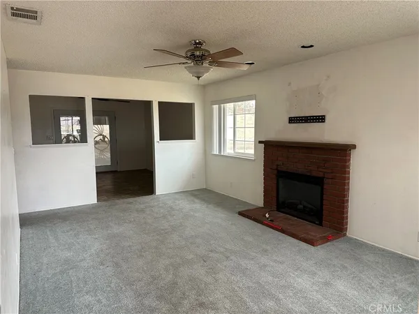 a view of a livingroom with a fireplace and window