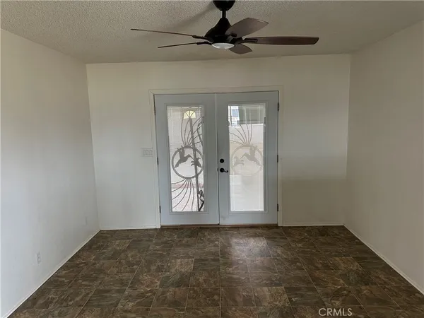an empty room with windows and fan