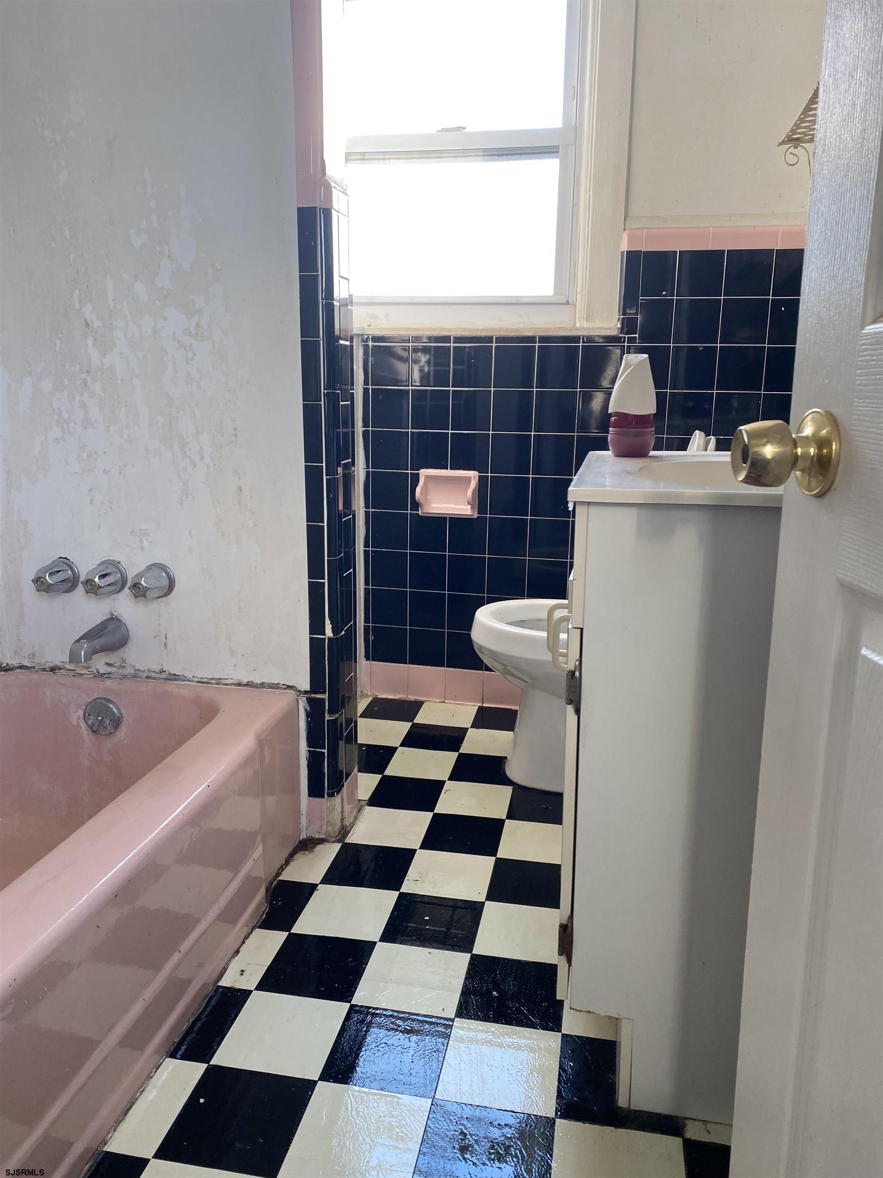 137 West Edgewater Avenue Pleasantville, NJ 08232 - Photo 17 of 36 a bathroom with a black white checkered floor and white cabinets