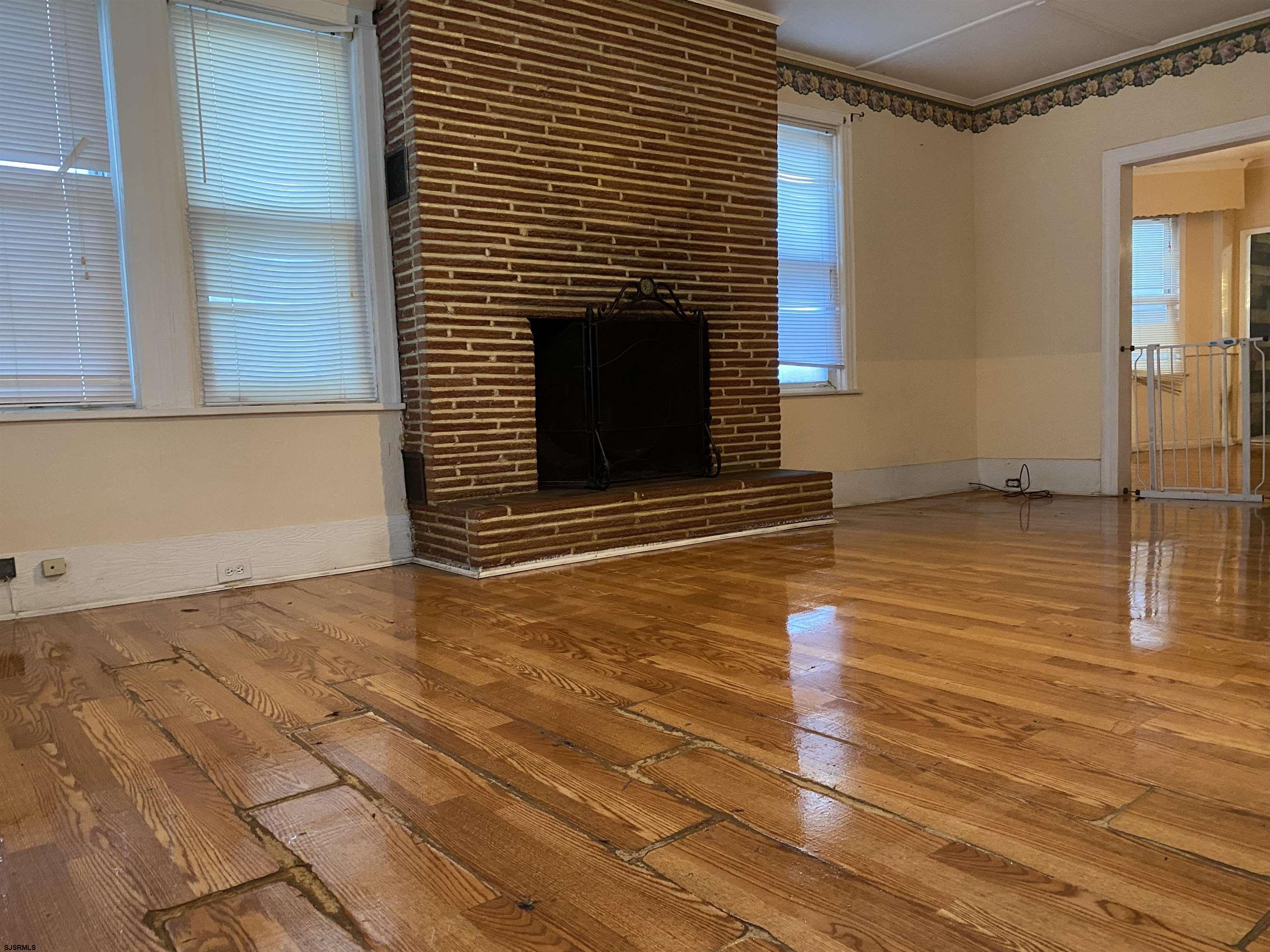 137 West Edgewater Avenue Pleasantville, NJ 08232 - Photo 3 of 36 a view of an empty room with wooden floor and a fireplace