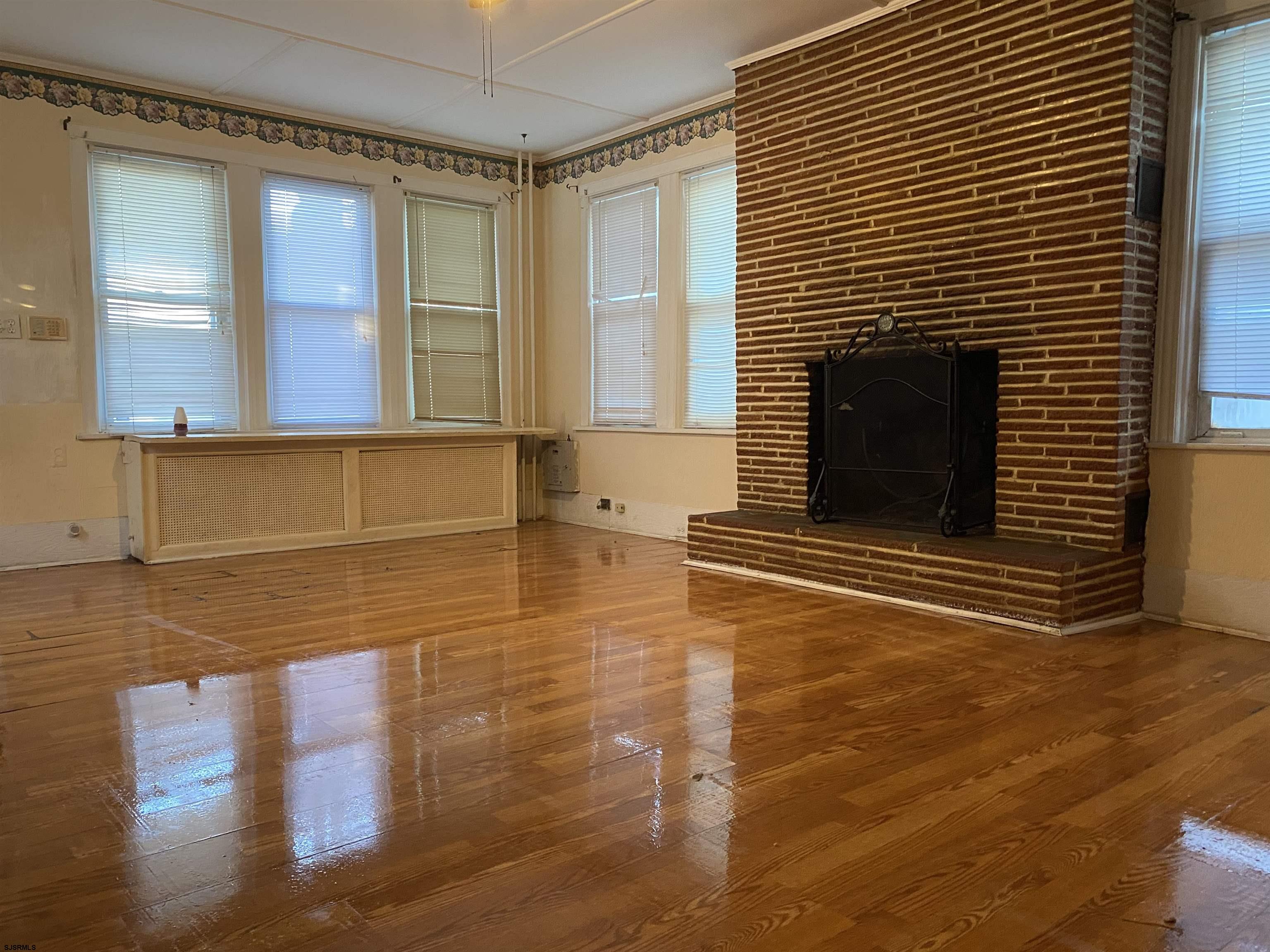 137 West Edgewater Avenue Pleasantville, NJ 08232 - Photo 4 of 36 a view of empty room with a fireplace and wooden floor
