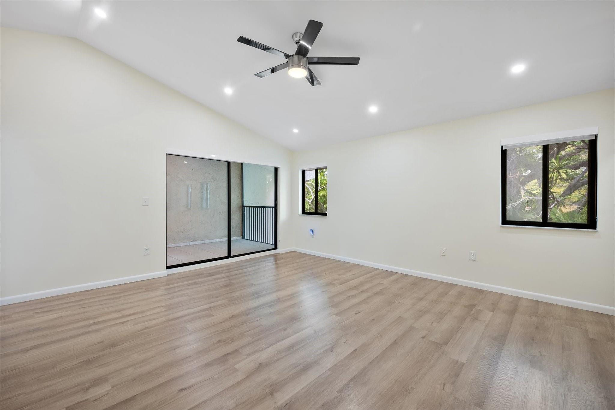 19986 Northeast 5th Court, Unit 4D Miami, FL 33179 - Photo 20 of 46 a view of an empty room with wooden floor and a ceiling fan