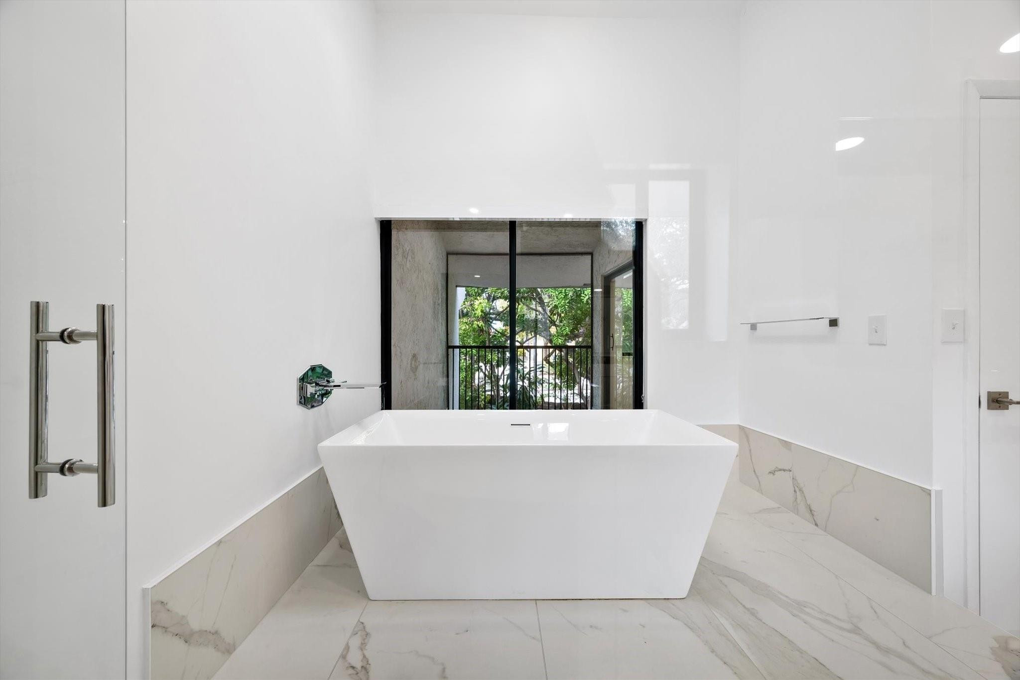 19986 Northeast 5th Court, Unit 4D Miami, FL 33179 - Photo 27 of 46 a white bath tub sitting in a bathroom