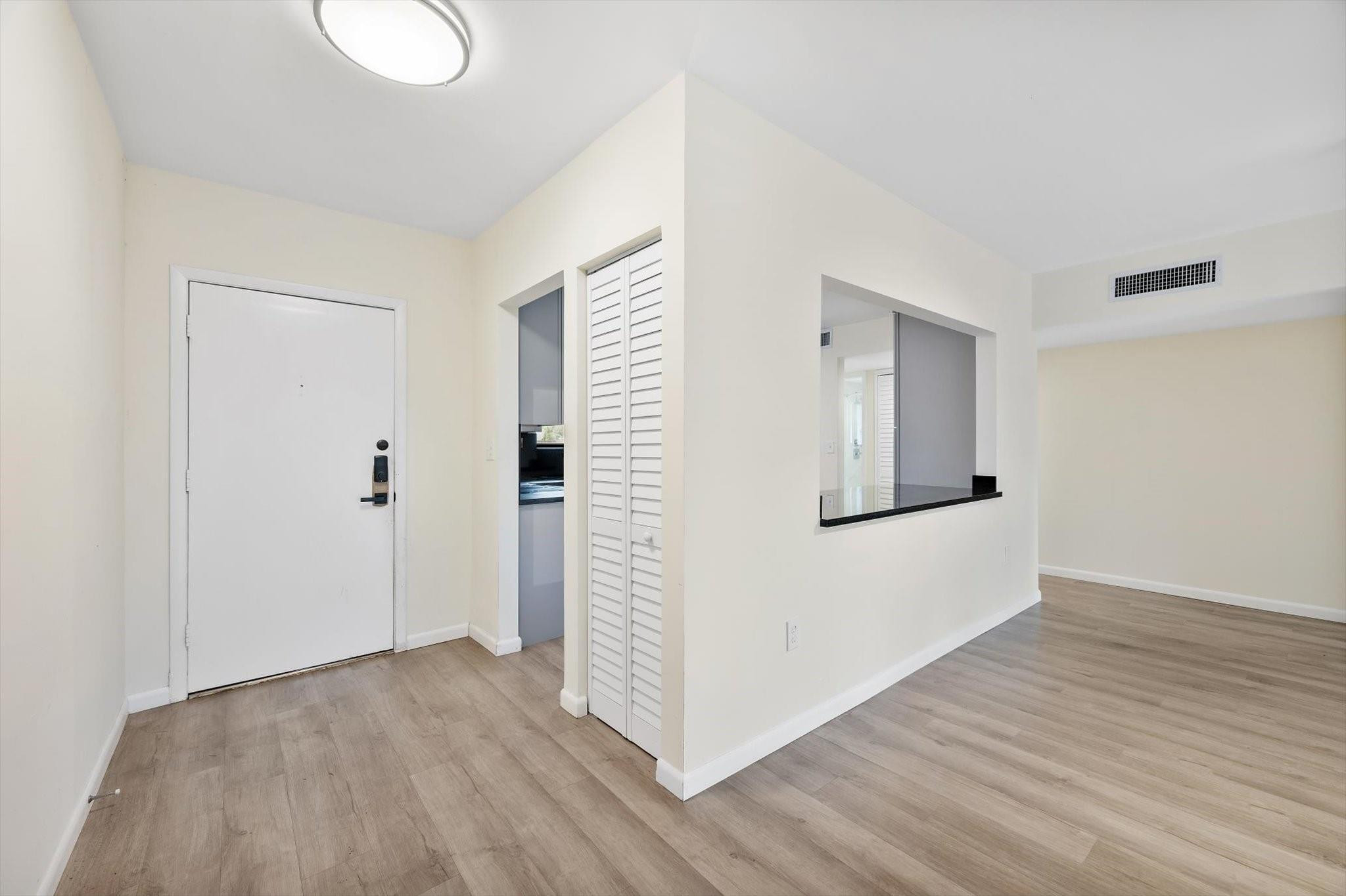 19986 Northeast 5th Court, Unit 4D Miami, FL 33179 - Photo 3 of 46 a view of an empty room with wooden floor and closet