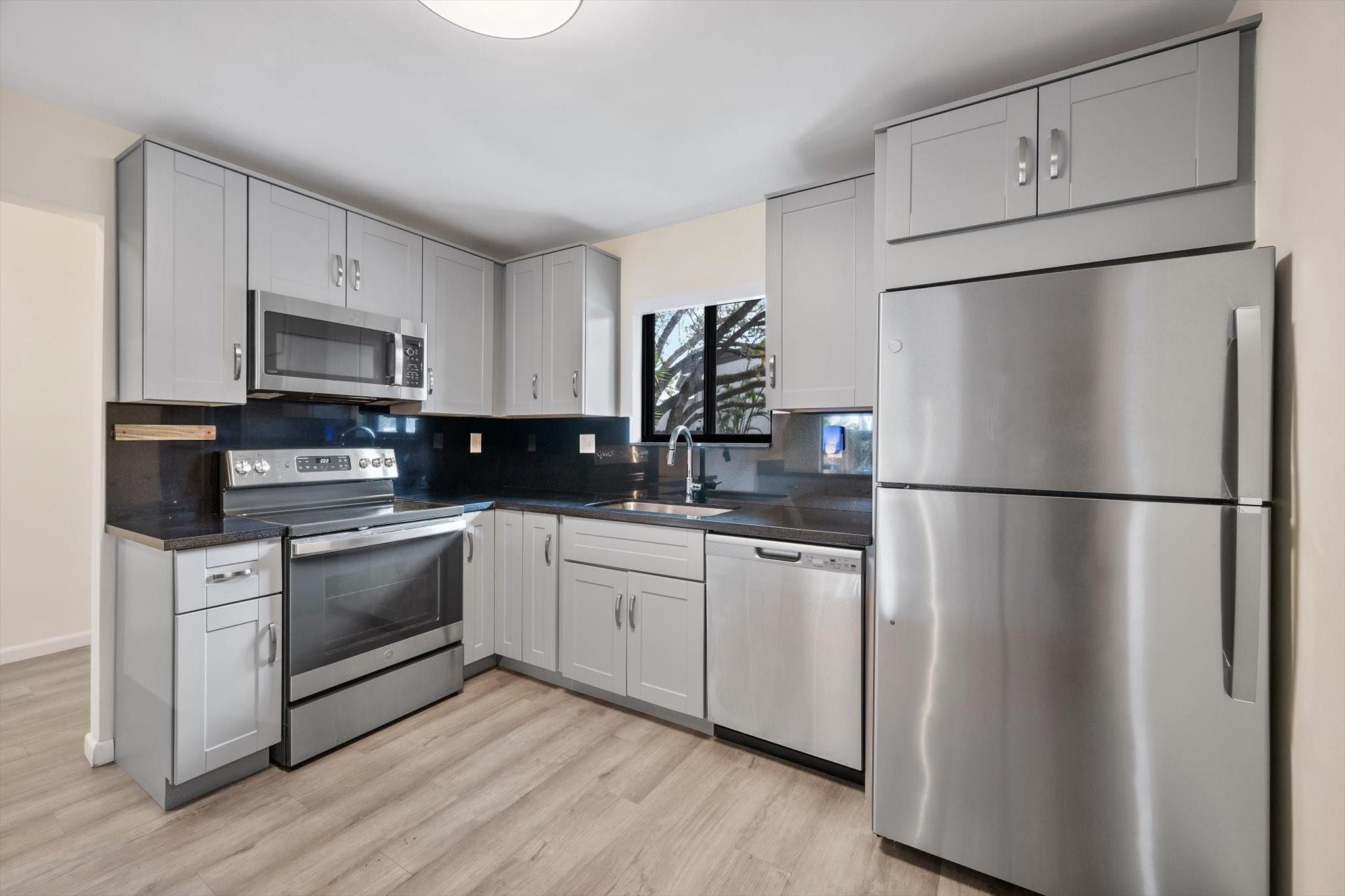 19986 Northeast 5th Court, Unit 4D Miami, FL 33179 - Photo 6 of 46 a kitchen with stainless steel appliances a refrigerator sink and microwave
