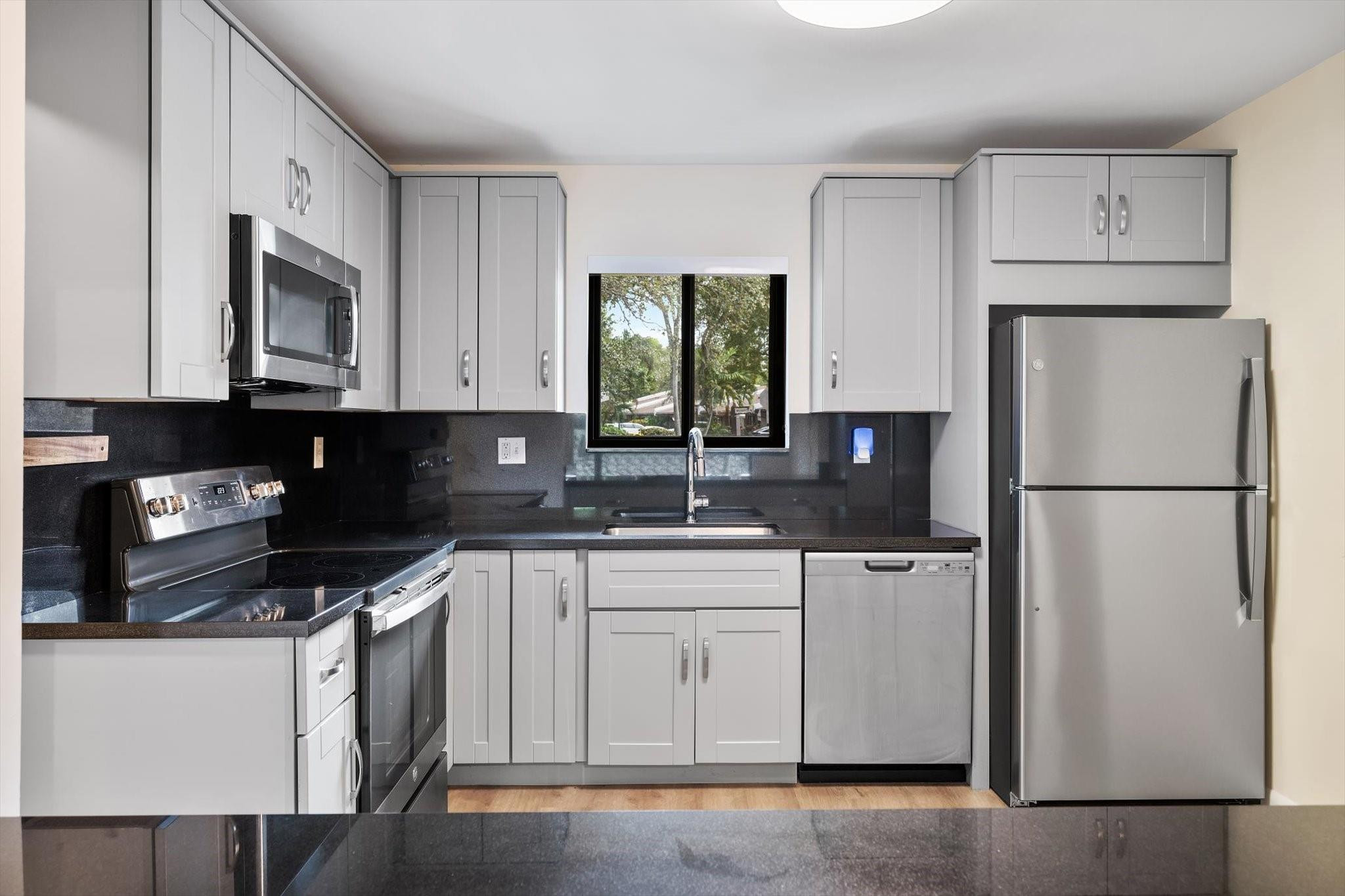 19986 Northeast 5th Court, Unit 4D Miami, FL 33179 - Photo 8 of 46 a kitchen with stainless steel appliances granite countertop a refrigerator sink and stove