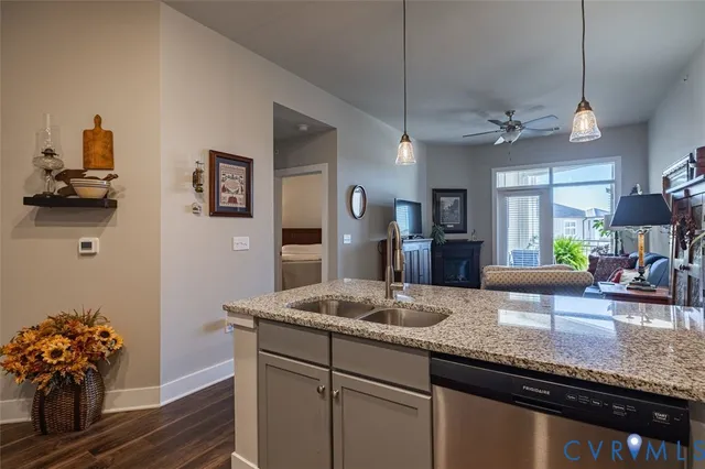 a kitchen with granite countertop a sink a counter space and stainless steel appliances