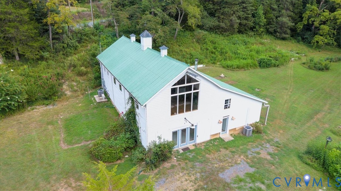 1208 Manteo Road Buckingham, VA 23921 - Photo 11 of 44 a view of a white house with a big yard and large trees