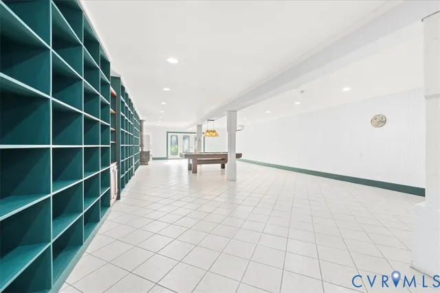 a view of an empty room with stairs and a workspace