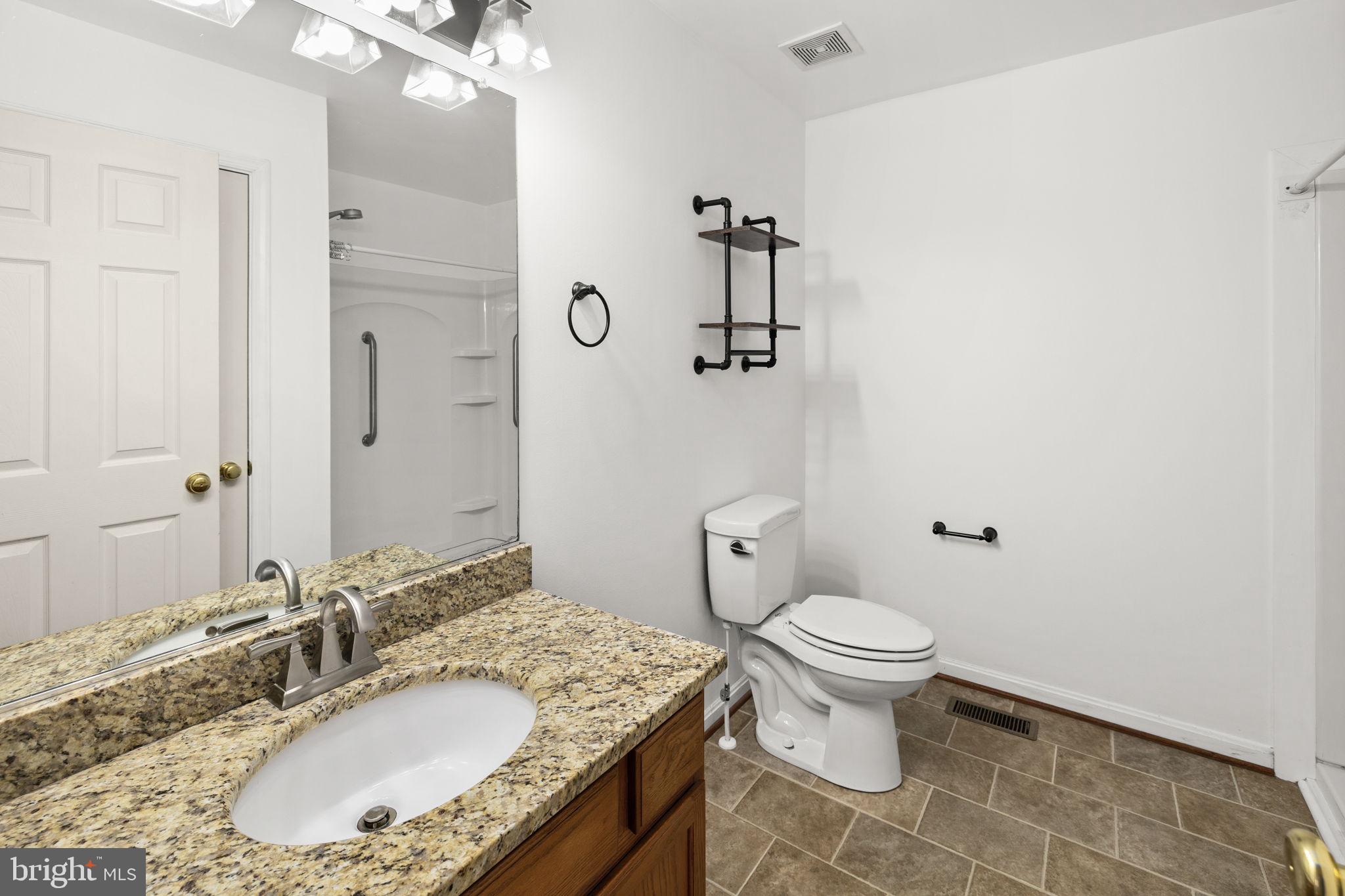 25281 Boling Lane Rhoadesville, VA 22542 - Photo 13 of 41 a bathroom with a granite countertop sink a toilet and a mirror