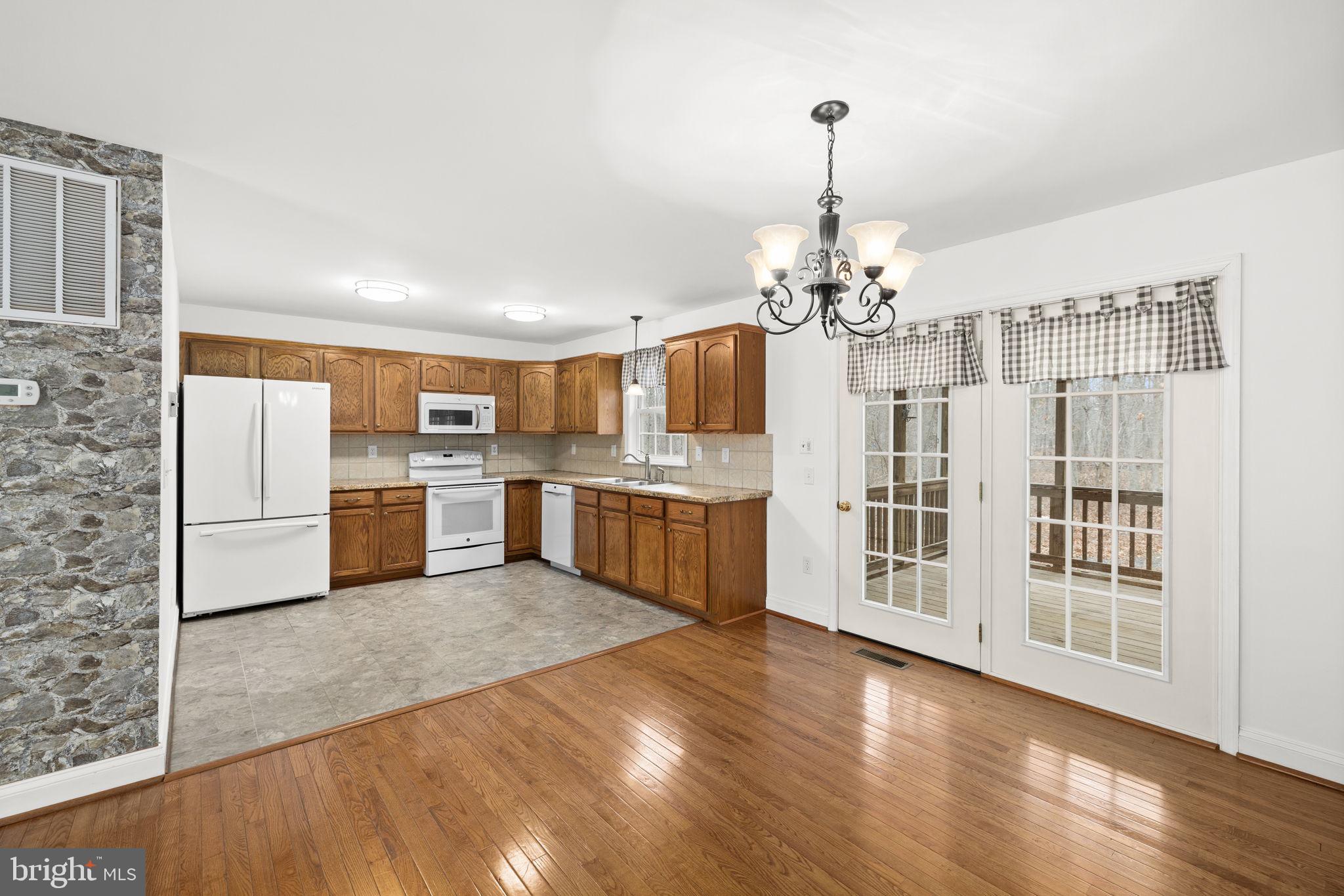 25281 Boling Lane Rhoadesville, VA 22542 - Photo 5 of 41 a view of a kitchen with refrigerator and wooden floor