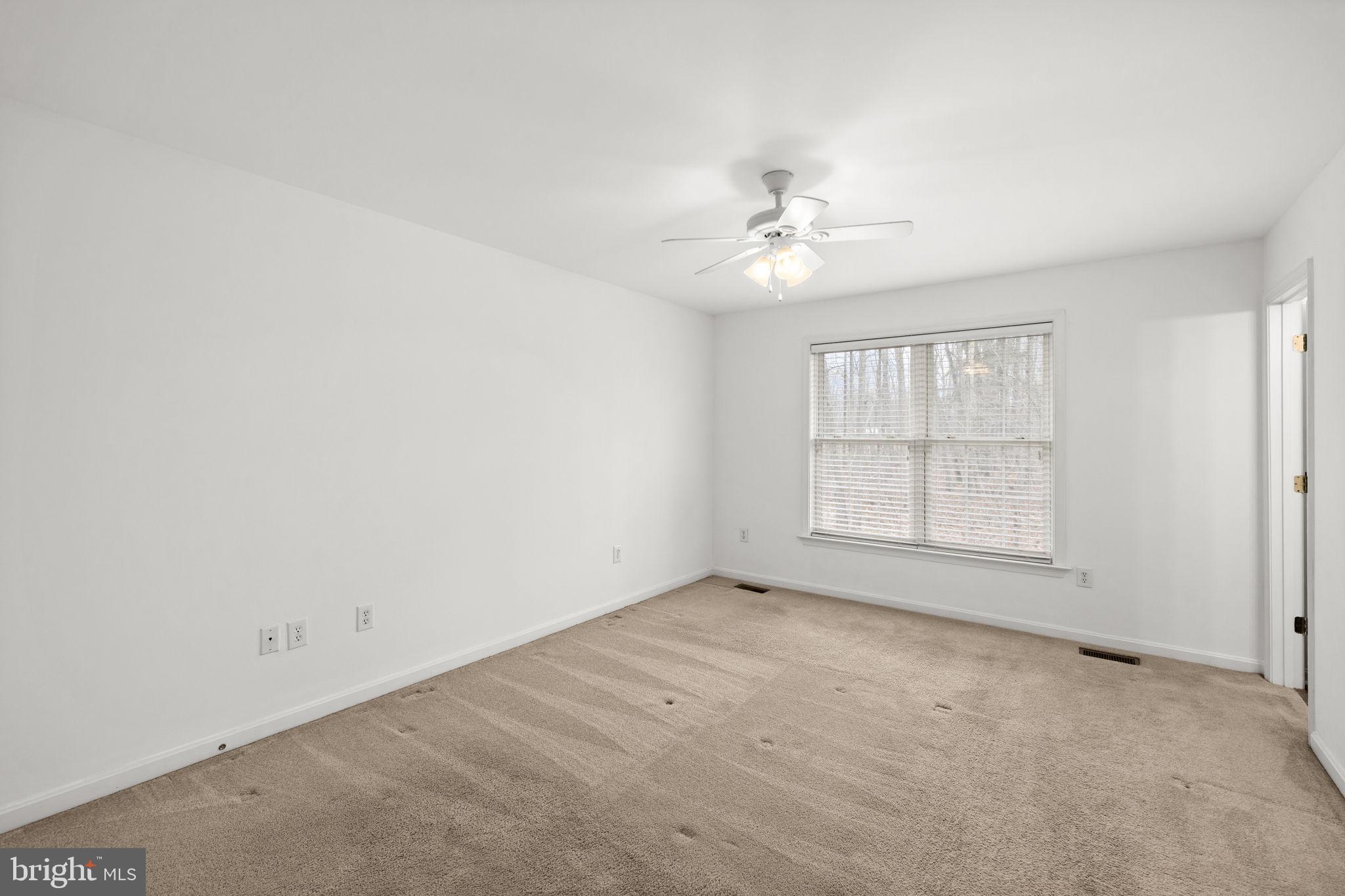 25281 Boling Lane Rhoadesville, VA 22542 - Photo 10 of 41 an empty room with chandelier fan and windows