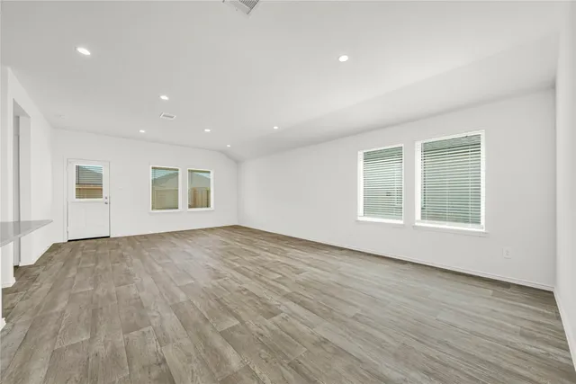 a view of empty room with wooden floor