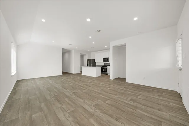 a kitchen with granite countertop a sink a stove top oven and refrigerator