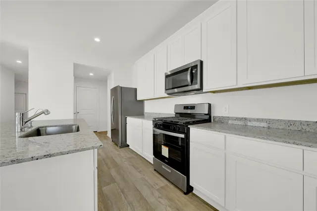 a view of kitchen with stainless steel appliances a sink and a refrigerator