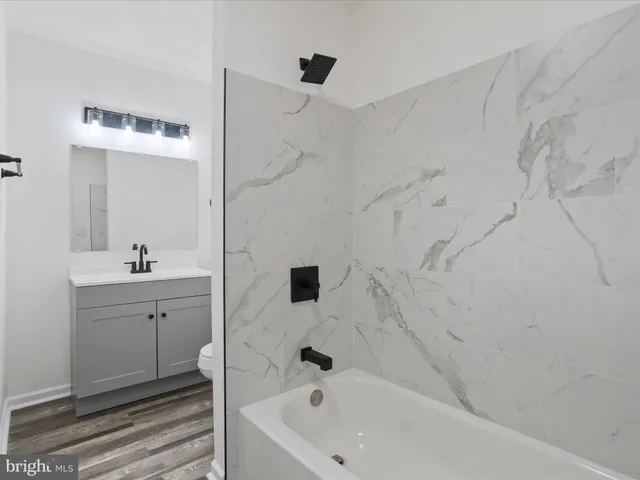 a bathroom with a bathtub sink and mirror