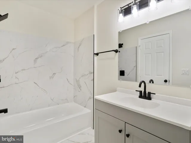 a bathroom with a sink a tub and a mirror