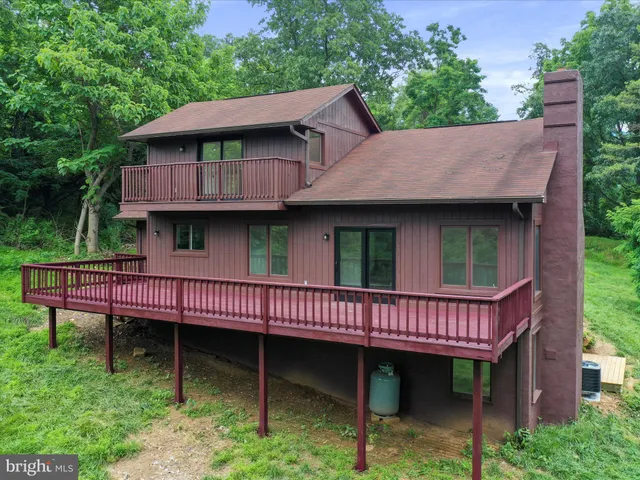 a view of a house with a wooden deck and furniture