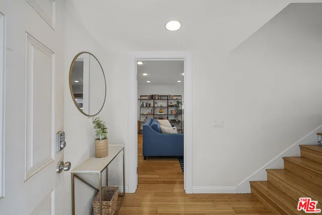 a view of a hallway with wooden floor and entryway