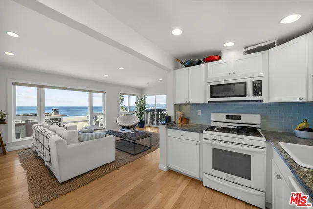 a view of kitchen with microwave stove top oven and cabinets