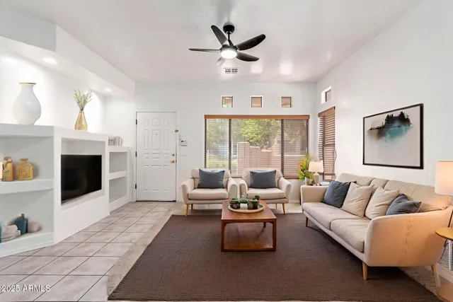 a living room with furniture fireplace and a large window