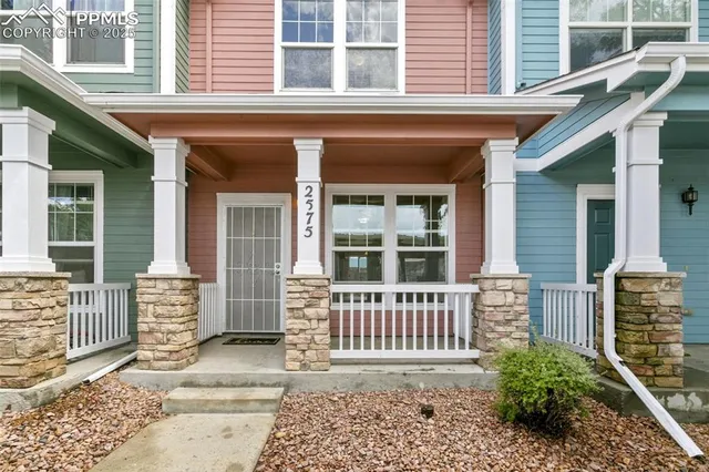 a view of a house with a small window and wooden fence