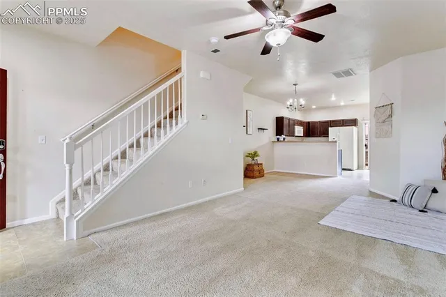a view of main area with chandelier fan and windows