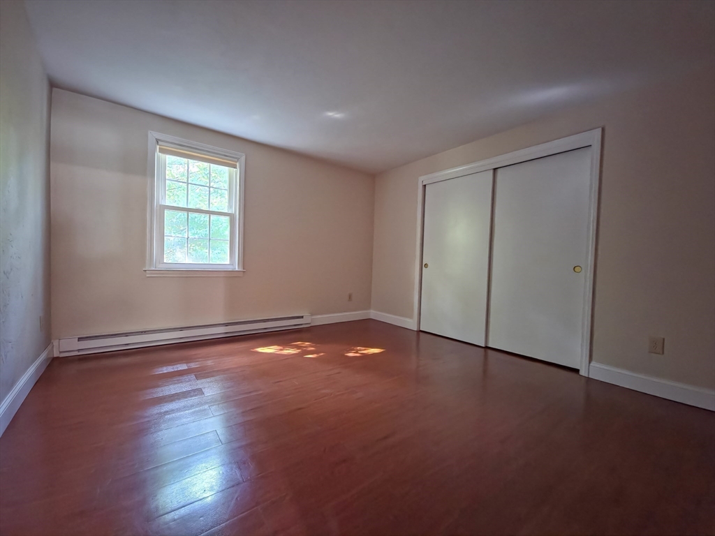 300 Falmouth Road, Unit 18E Mashpee, MA 02649 - Photo 16 of 33 an empty room with wooden floor and windows